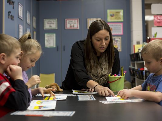 Teacher working with students at table