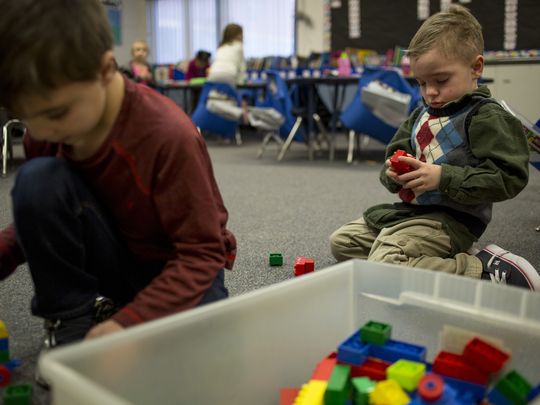2 students working with blocks on floor